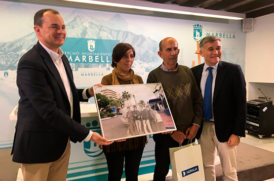 The winner of the contest for the best photography of Marbella in images, Susana Sánchez, poses with her image of the port of Marbella in the 60s. She is flanked by the manager of Hidralia, Carlos Corral, family members and members of the Malaga town council.